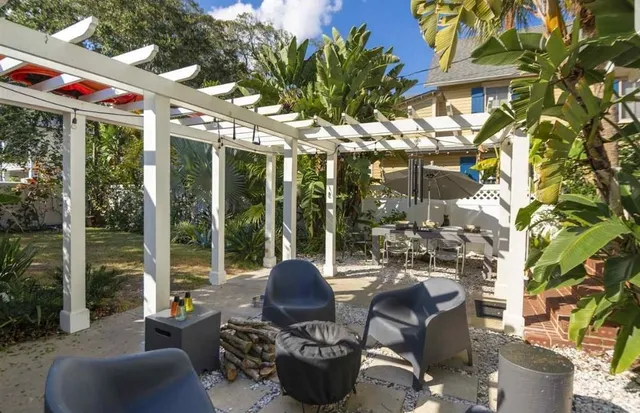a view of a patio with couches table and chairs and potted plants