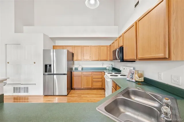 a kitchen with stainless steel appliances granite countertop a sink refrigerator and cabinets