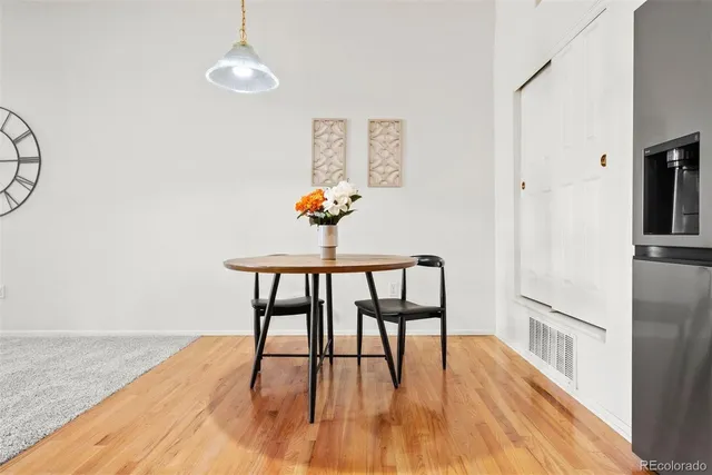 a dining room with wooden floor a chandelier a wooden table and chairs