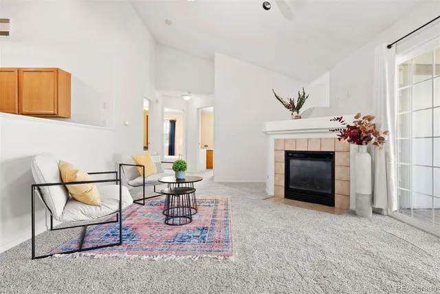 a living room with furniture a fireplace and a potted plant