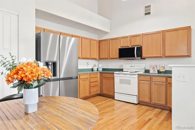 a kitchen with stainless steel appliances granite countertop a refrigerator sink and microwave