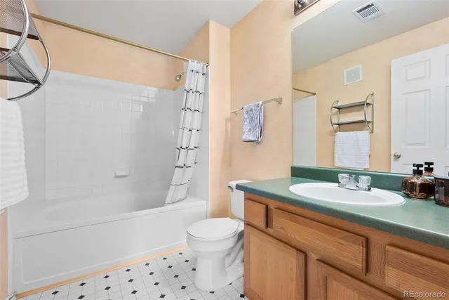 a bathroom with a granite countertop sink toilet a shower and a mirror