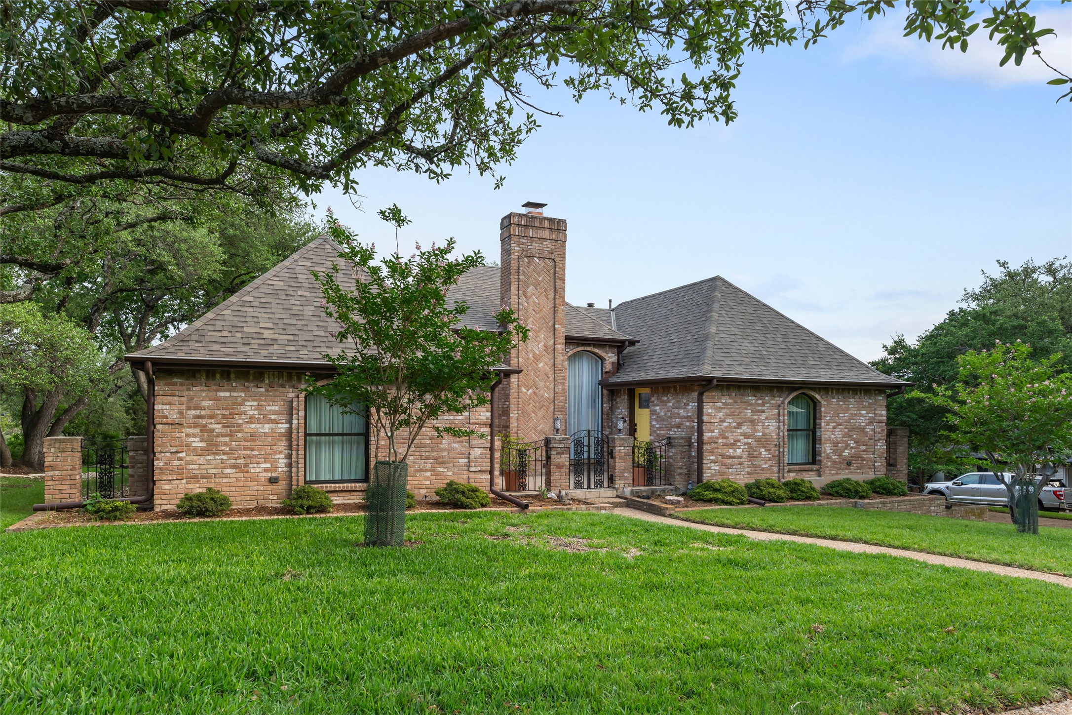 5307 Musket Ridge Austin, TX 78759 - Photo 1 of 1 Brick exterior residence with a prominent chimney structure and a peaked shingle roof