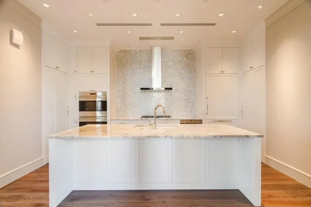 a view of kitchen with kitchen island a sink wooden floor and glass door