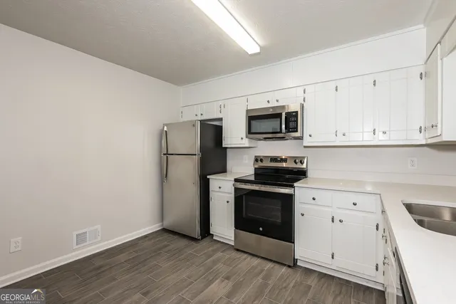 a kitchen with a refrigerator stove and white cabinets