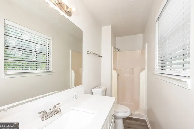 a bathroom with a sink a toilet and a shower curtain