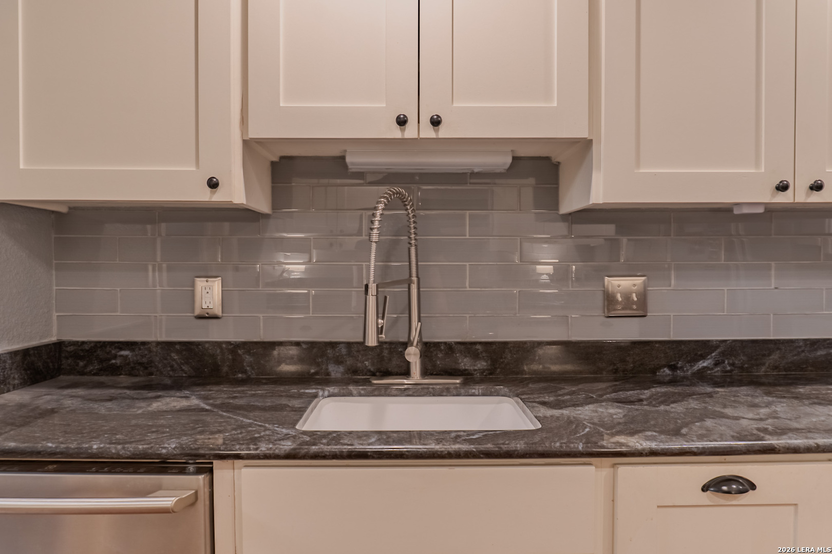 8942 Willmon Way Windcrest, TX 78239 - Photo 21 of 44 a kitchen with granite countertop granite countertop white cabinets and a stove