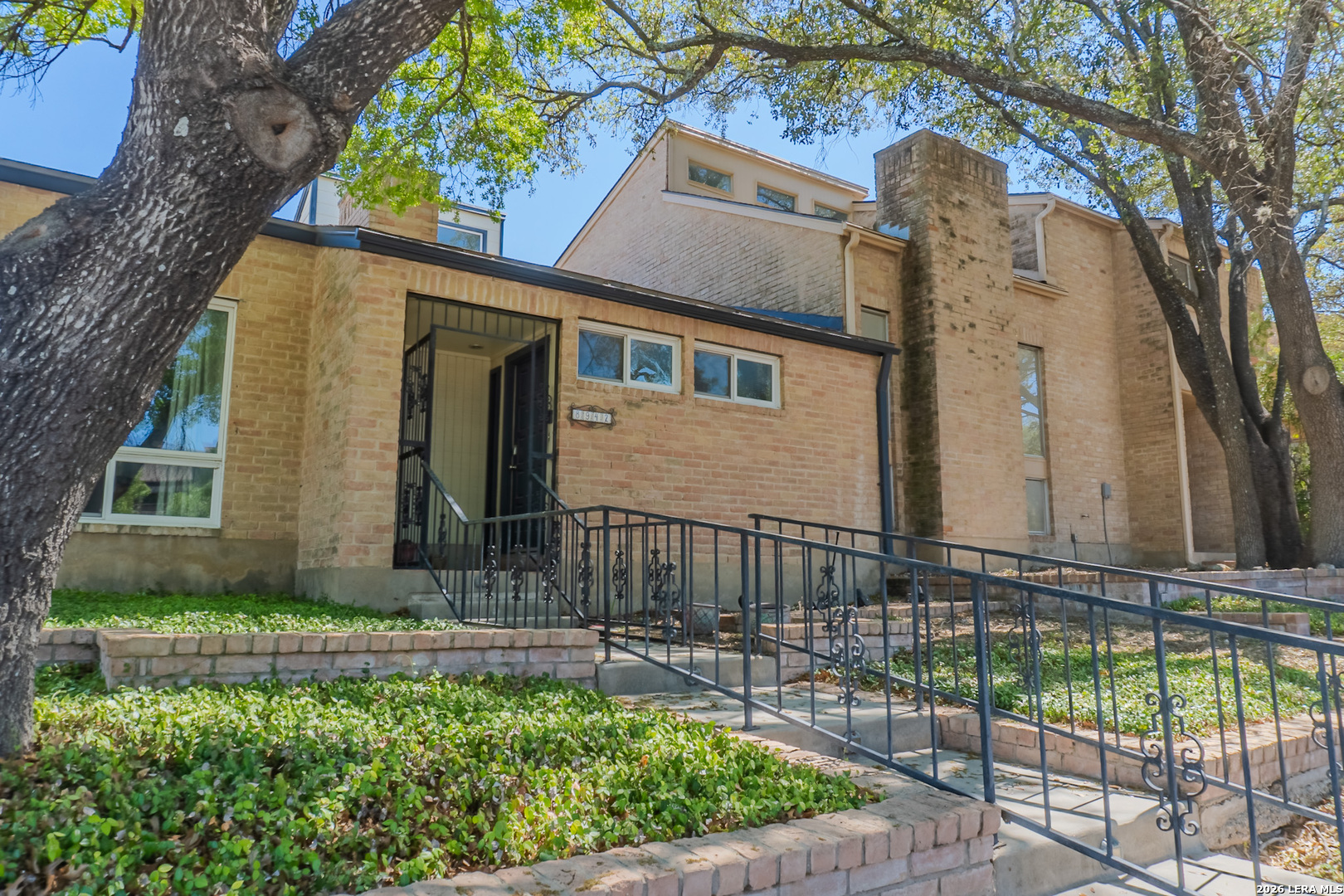 8942 Willmon Way Windcrest, TX 78239 - Photo 3 of 44 front view of a house with a garden