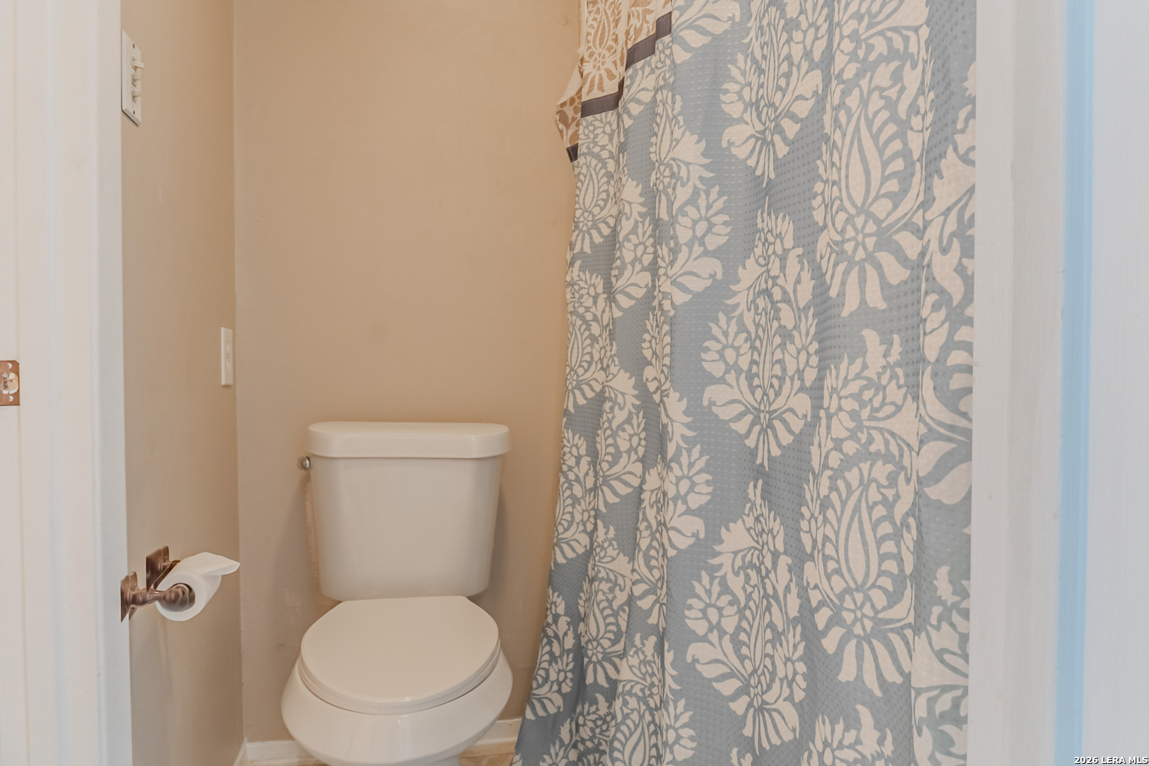 8942 Willmon Way Windcrest, TX 78239 - Photo 39 of 44 a white toilet sitting next to a shower curtain