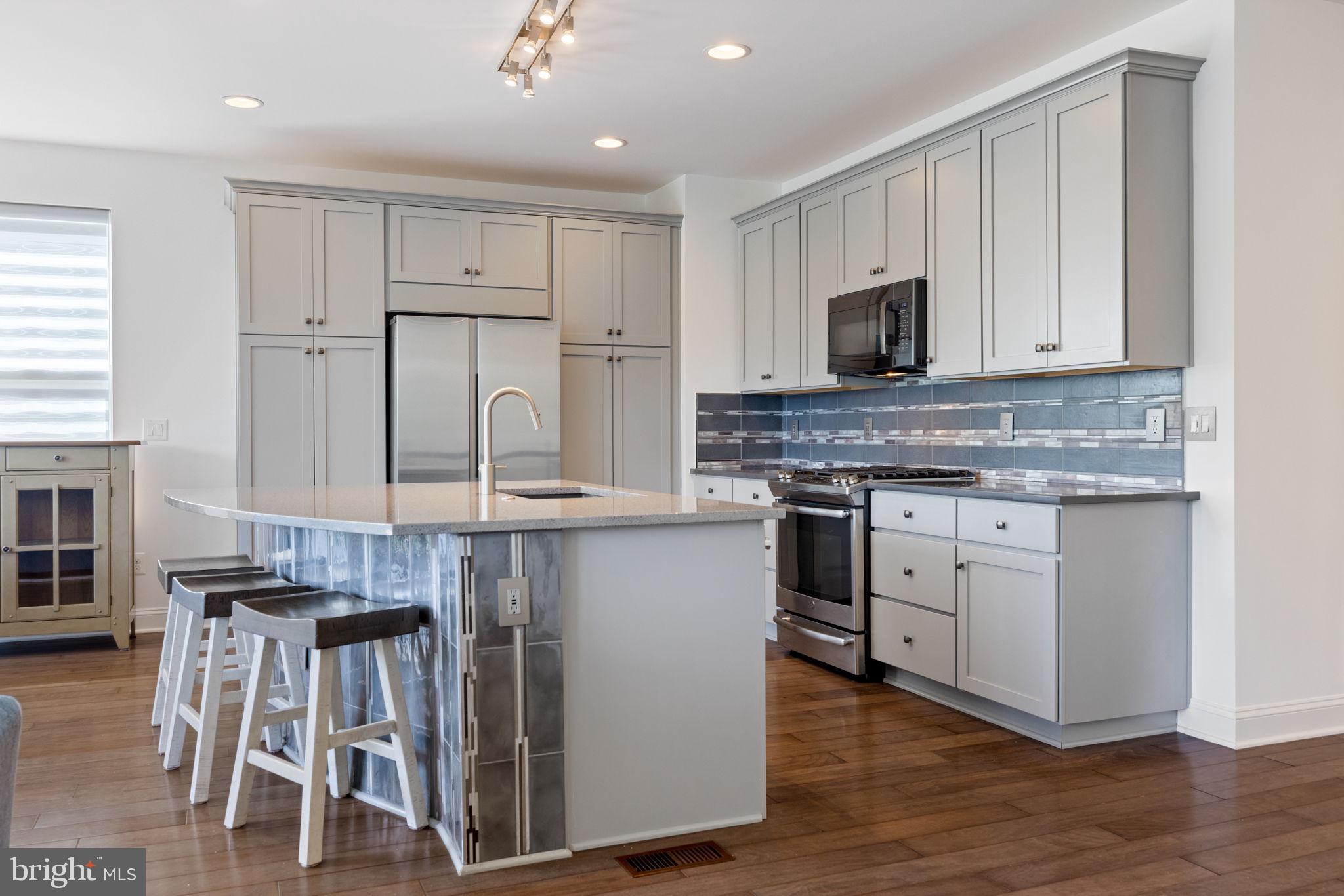 112 Flycatcher Way White Post, VA 22663 - Photo 16 of 59 a kitchen with kitchen island granite countertop wooden floors and white cabinets