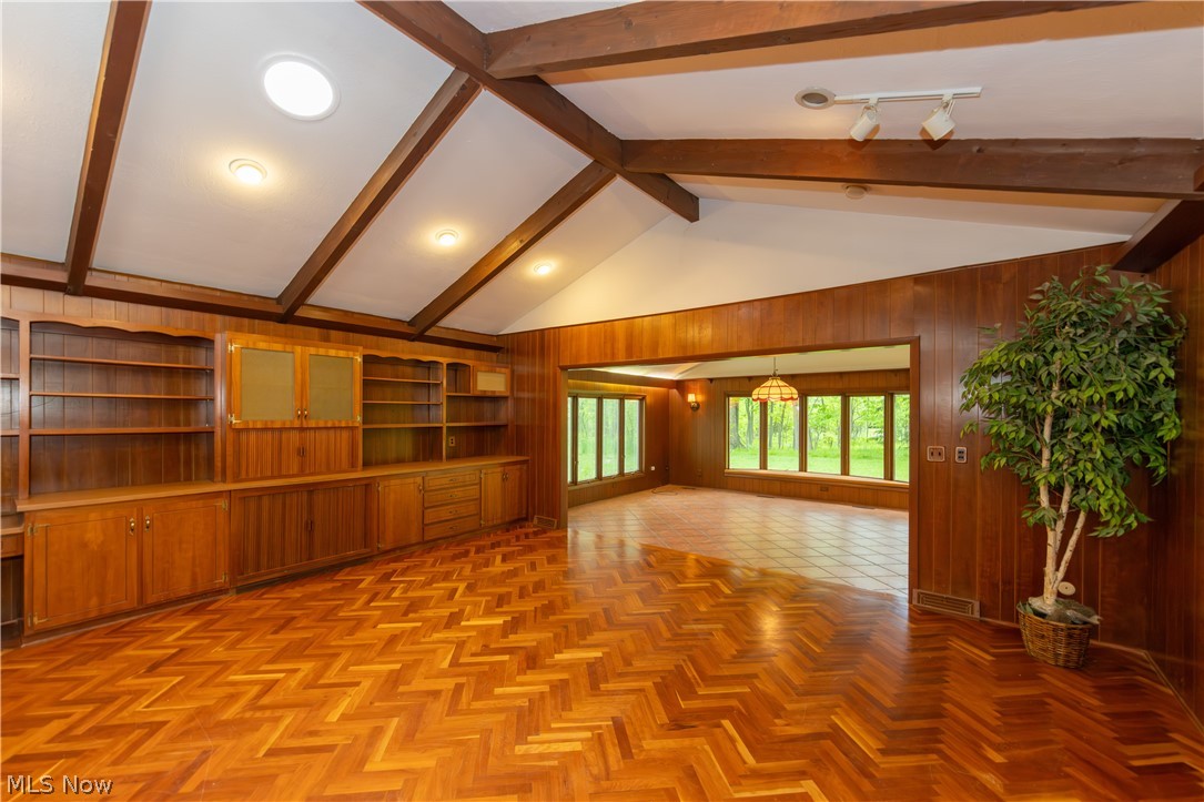25001 Letchworth Road Beachwood, OH 44122 - Photo 15 of 50 Vaulted ceiling with exposed wood beams, built-in shelving, wood-finish flooring in a herringbone pattern, and recessed lighting