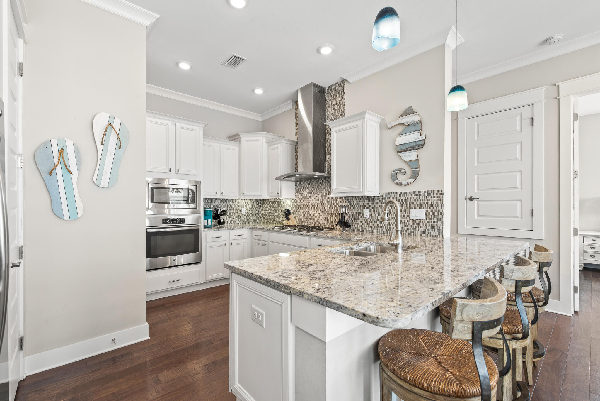 26 Milestone Dr Inlet Beach, Unit C Inlet Beach, FL 32461 - Photo 10 of 36 a kitchen with kitchen island granite countertop a sink cabinets and wooden floor