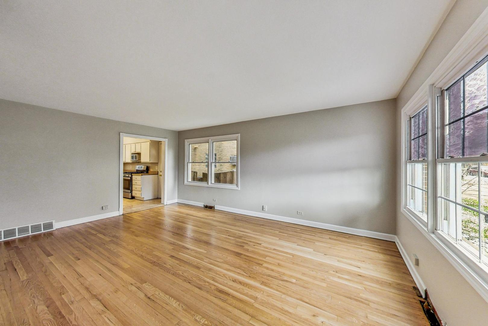 2212-2214 Oakton Street Park Ridge, IL 60068 - Photo 5 of 43 a view of an empty room with wooden floor and a window