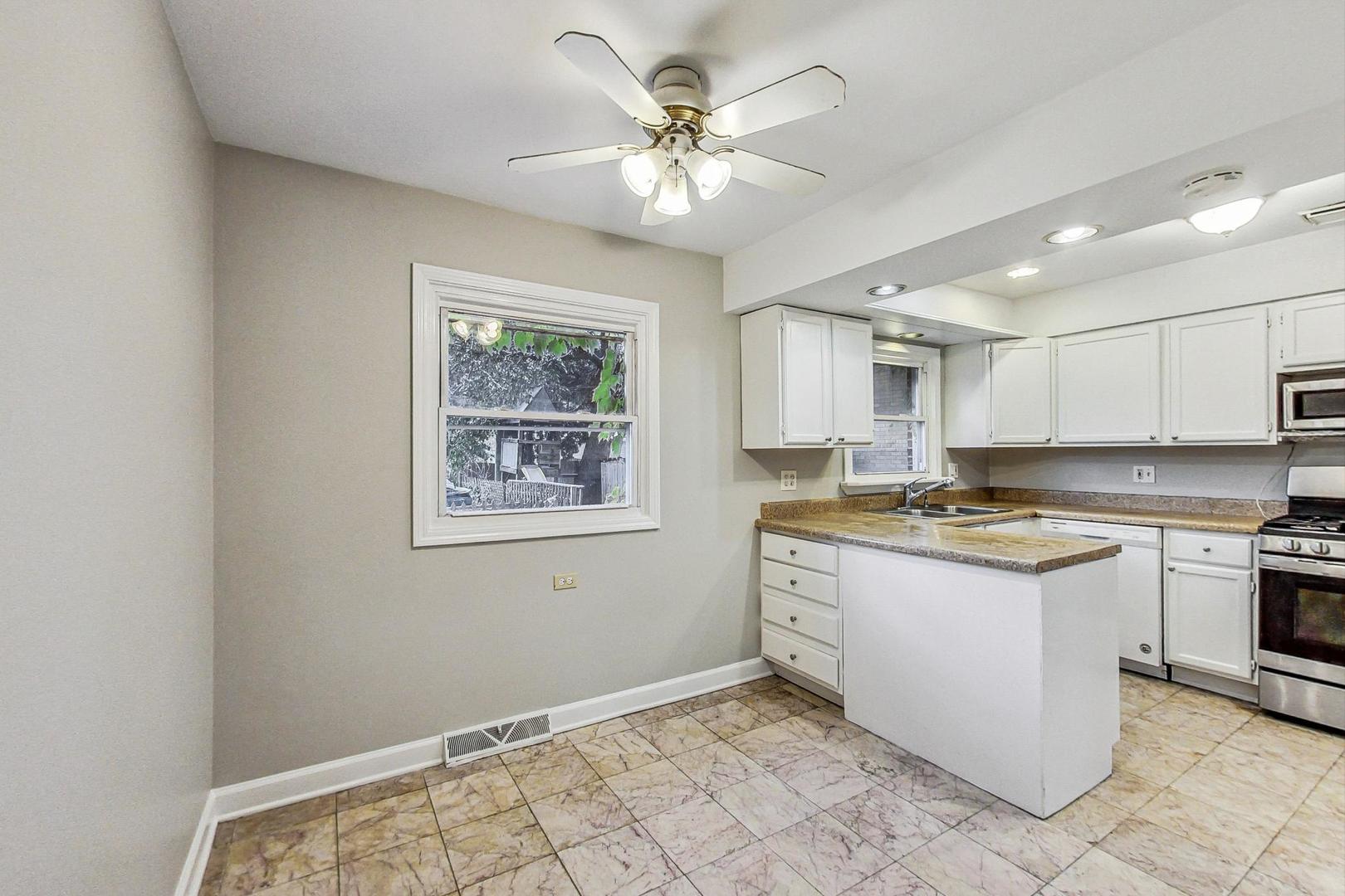 2212-2214 Oakton Street Park Ridge, IL 60068 - Photo 8 of 43 a kitchen with stainless steel appliances granite countertop a stove and a white cabinets