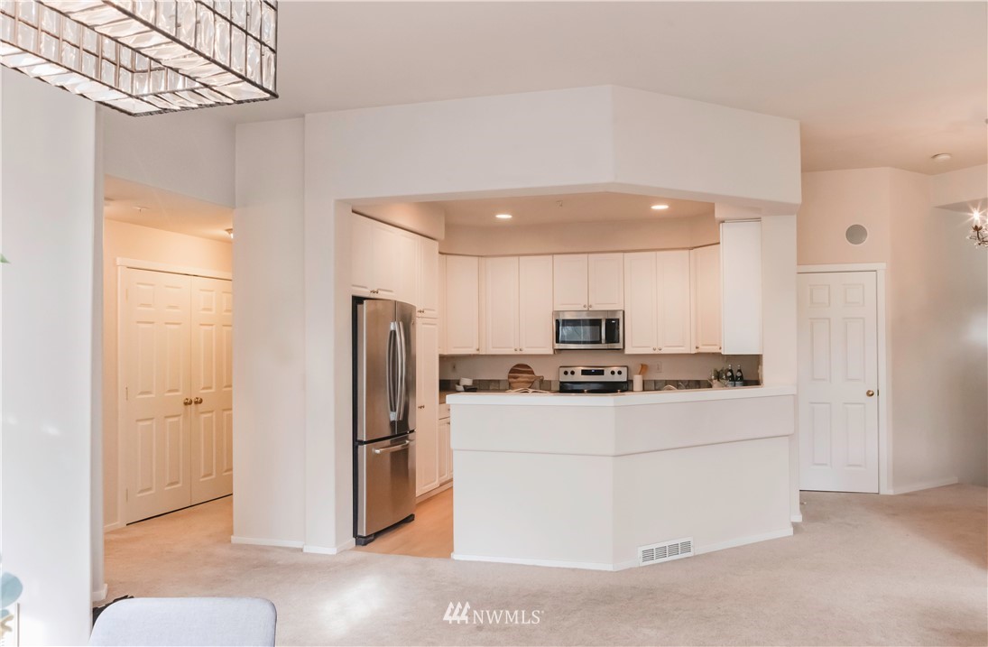 4319 Northeast 5th Court, Unit 102 Renton, WA 98059 - Photo 13 of 32 a kitchen with stainless steel appliances a refrigerator and a stove top oven