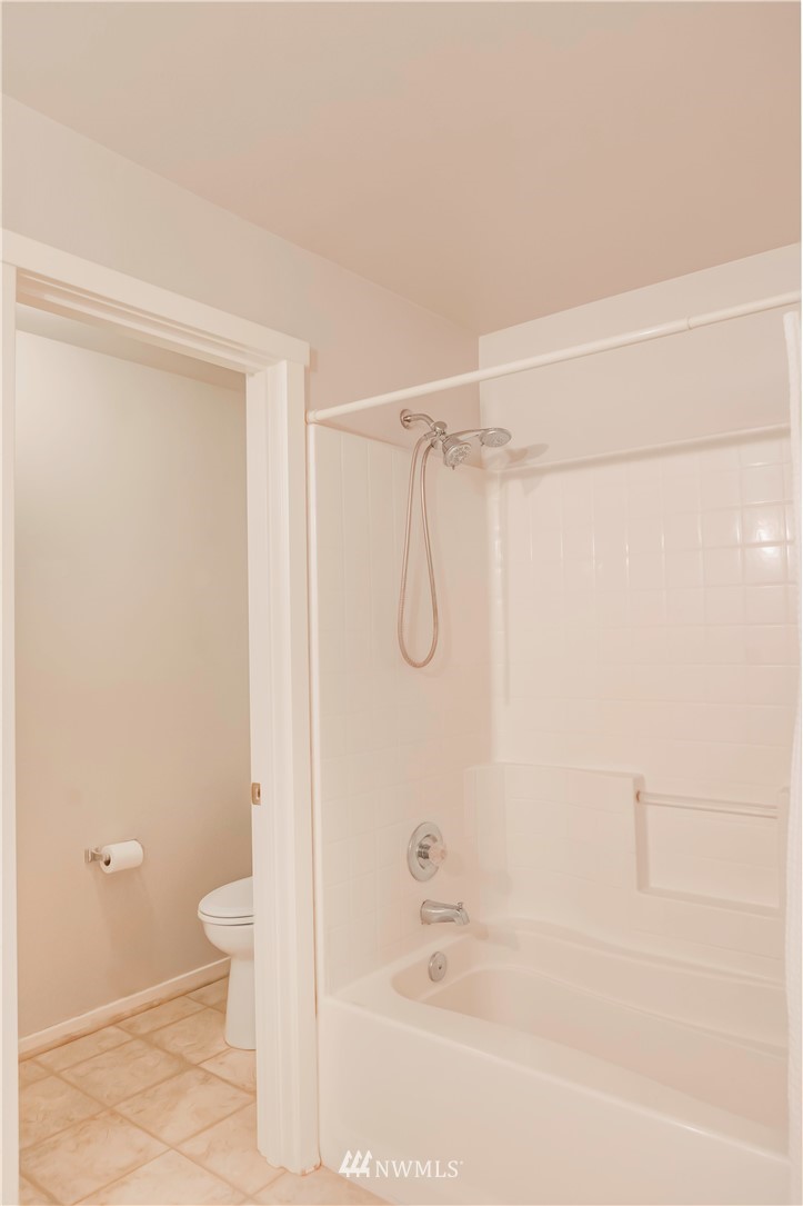 4319 Northeast 5th Court, Unit 102 Renton, WA 98059 - Photo 23 of 32 a bathroom with a shower and a toilet