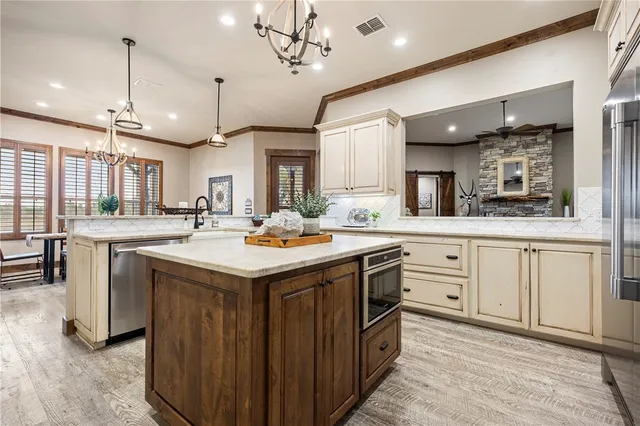 a kitchen with stainless steel appliances granite countertop a sink a stove and a wooden floors