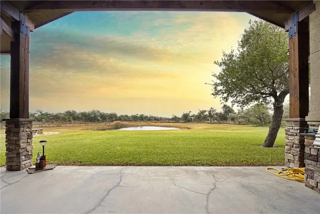 a view of a house with a big yard and large trees
