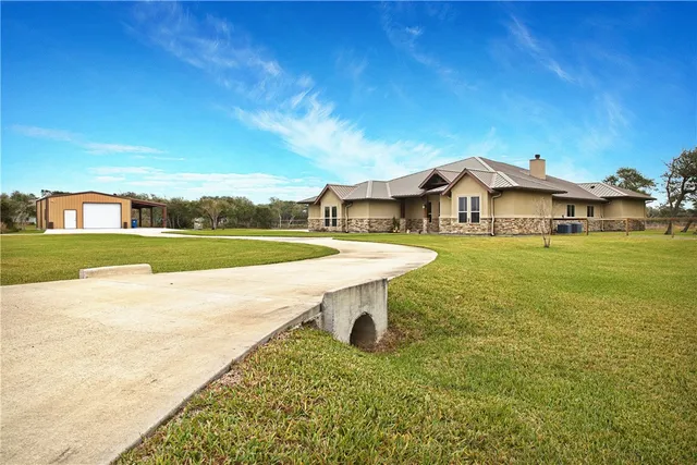 a view of a white house with a swimming pool and a yard