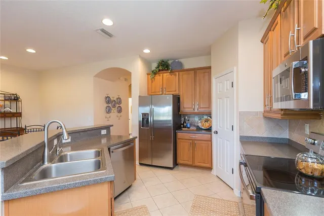 a kitchen with stainless steel appliances granite countertop a refrigerator and a sink