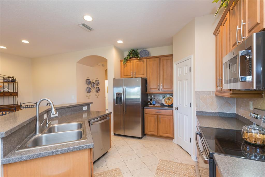 2816 Graphite Court Valrico, FL 33594 - Photo 12 of 57 a kitchen with stainless steel appliances granite countertop a refrigerator and a sink