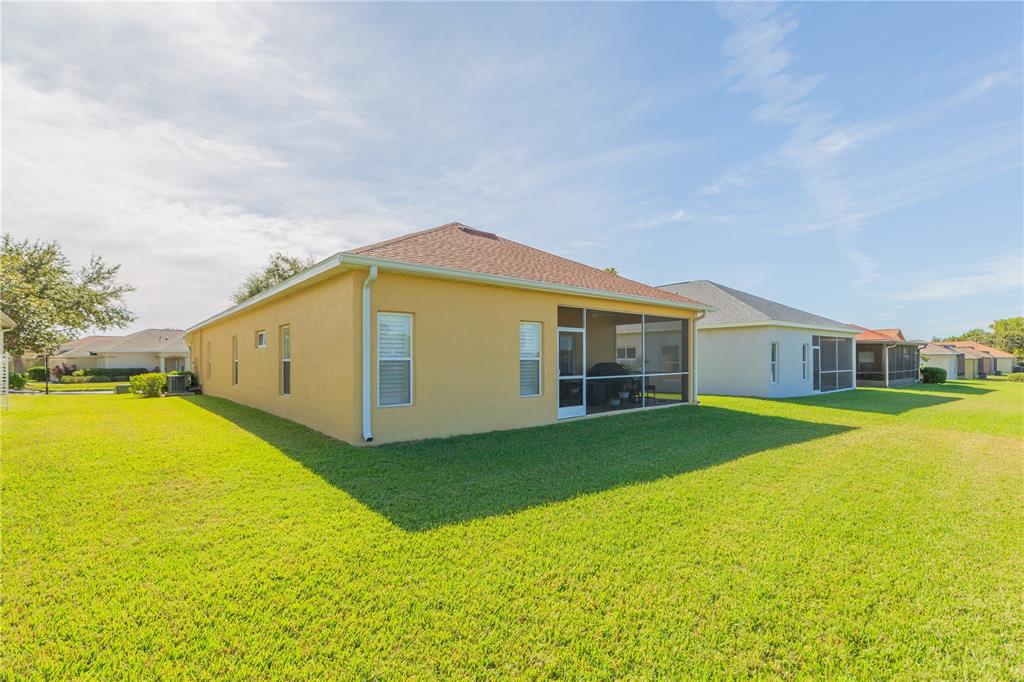 2816 Graphite Court Valrico, FL 33594 - Photo 38 of 57 a yellow house with swimming pool in front of it