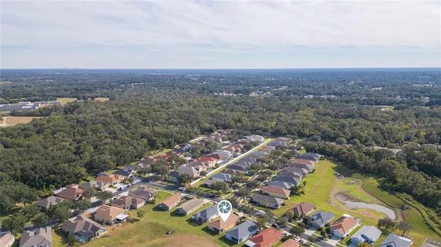 an aerial view of a house with a garden and lake view