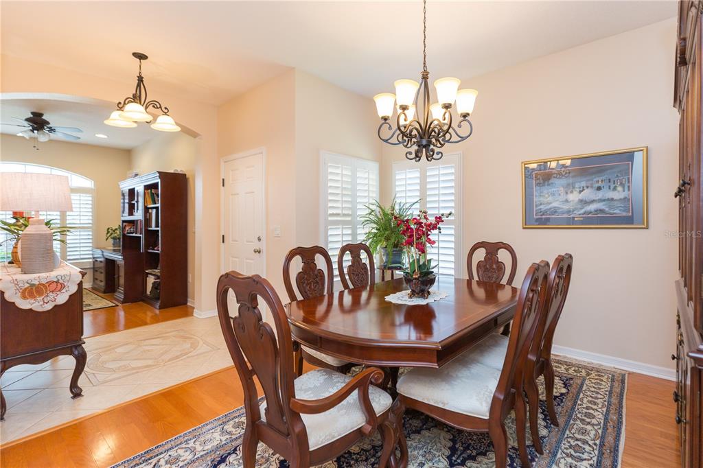2816 Graphite Court Valrico, FL 33594 - Photo 8 of 57 a dining room with furniture a chandelier and wooden floor