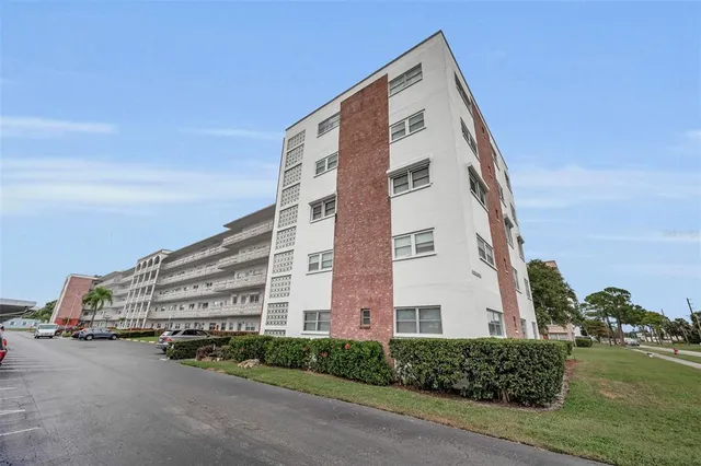 a view of a hallway with wooden floor and a bathroom