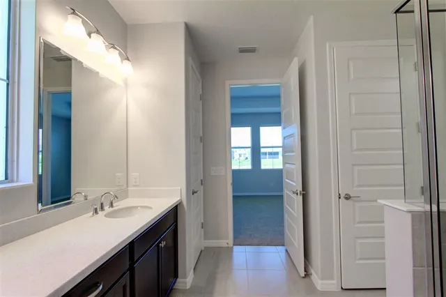 a en suite bathroom with a granite countertop sink and a mirror