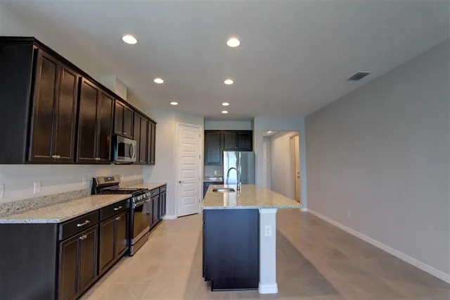a kitchen with stainless steel appliances granite countertop a refrigerator and a stove top oven