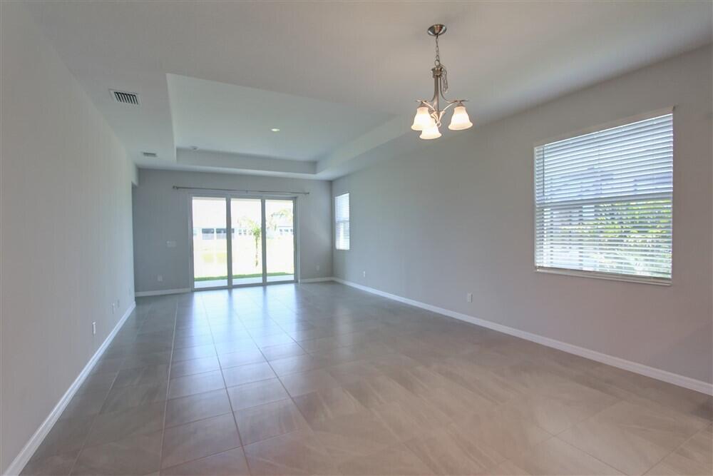 2508 Pangea Circle Melbourne, FL 32940 - Photo 27 of 34 an empty room with wooden floor chandelier and windows