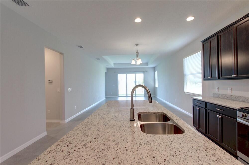 2508 Pangea Circle Melbourne, FL 32940 - Photo 10 of 34 a kitchen with granite countertop a sink and a refrigerator