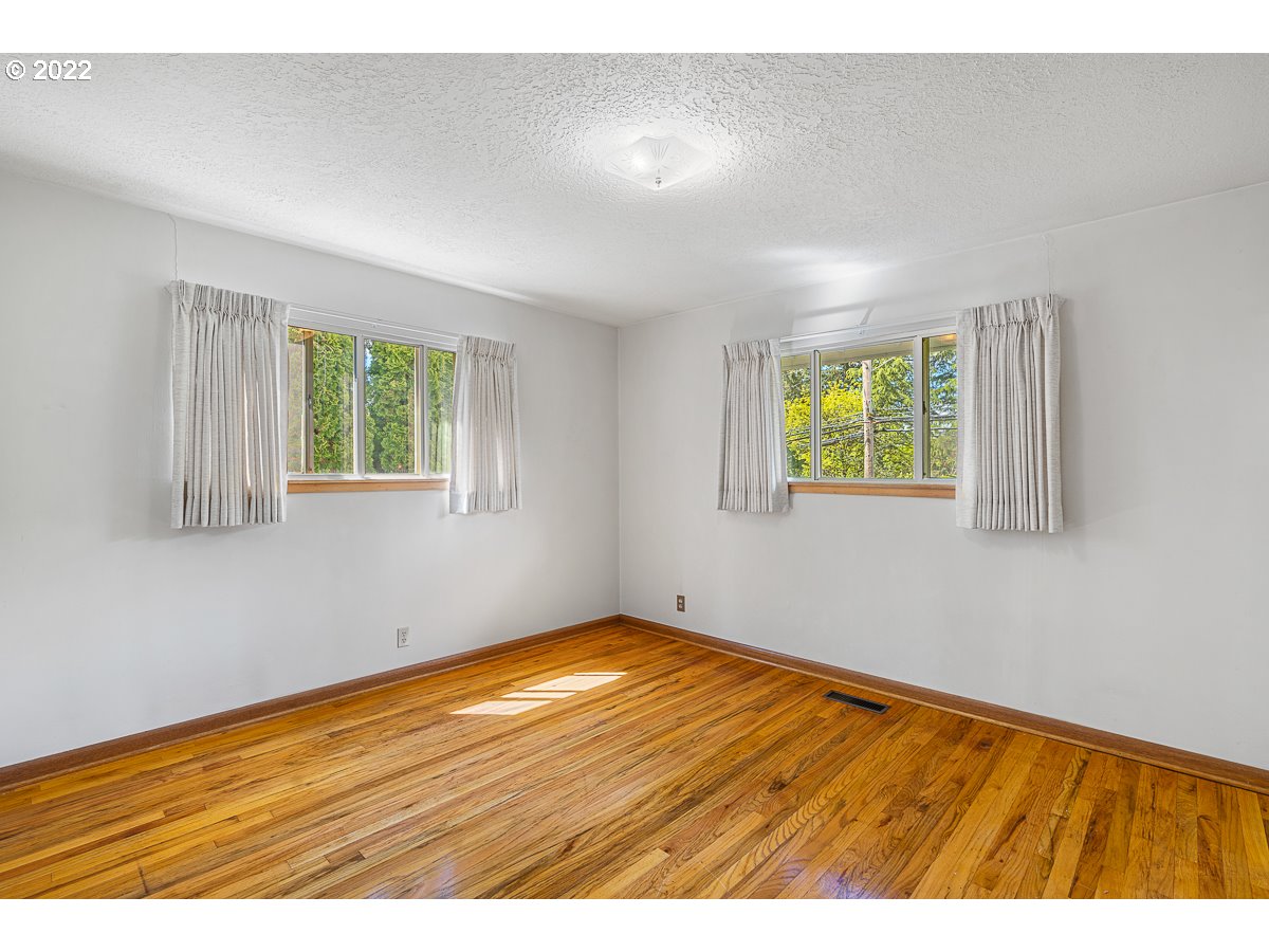 9020 Southwest Terwilliger Boulevard Portland, OR 97219 - Photo 14 of 31 a view of an empty room with wooden floor and a window