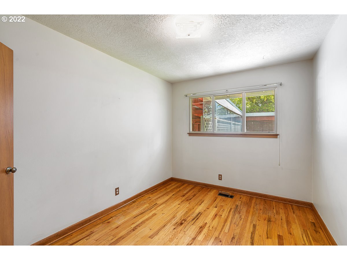 9020 Southwest Terwilliger Boulevard Portland, OR 97219 - Photo 15 of 31 a view of an empty room with wooden floor and a window