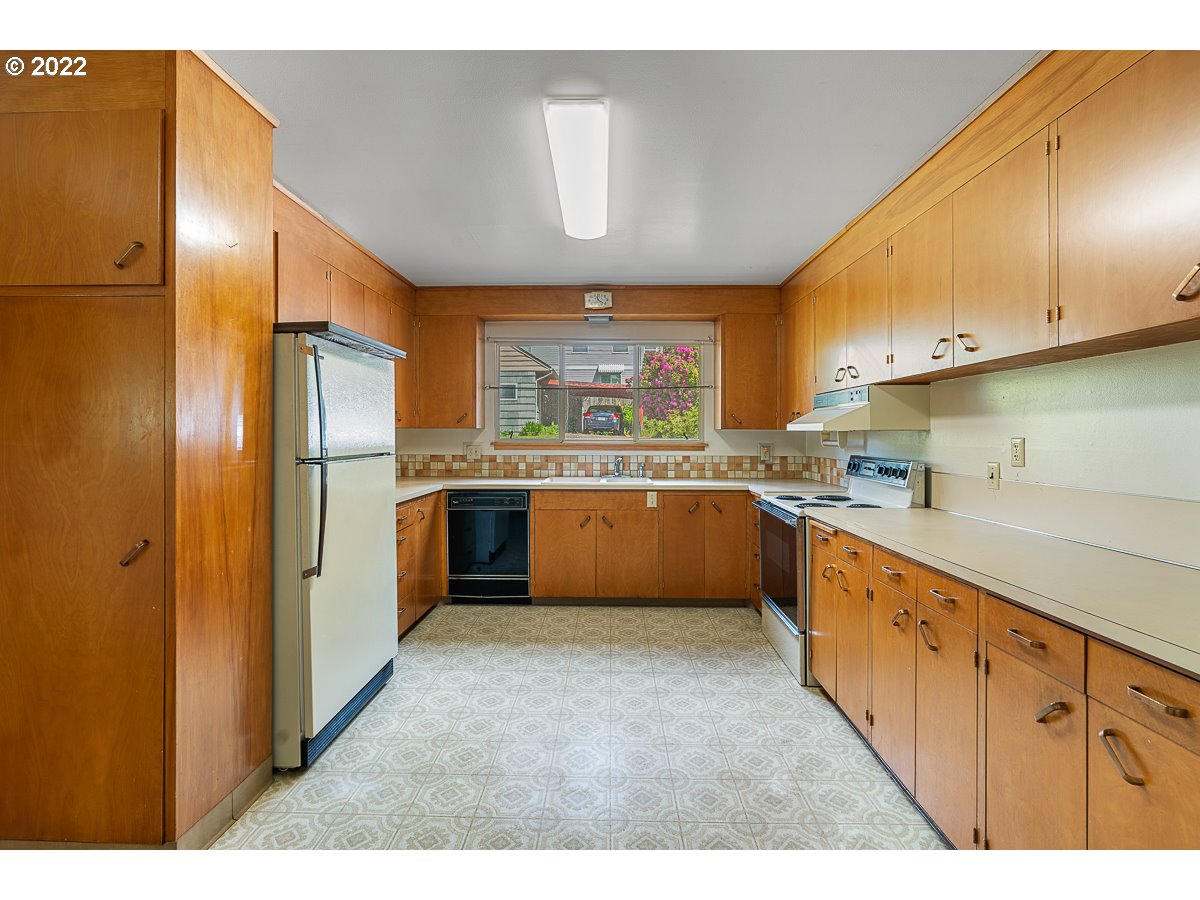 9020 Southwest Terwilliger Boulevard Portland, OR 97219 - Photo 8 of 31 a large kitchen with stainless steel appliances kitchen island granite countertop a refrigerator and a sink