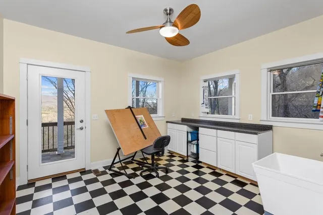 a living room with a black white checkered floor with a dining table and chairs