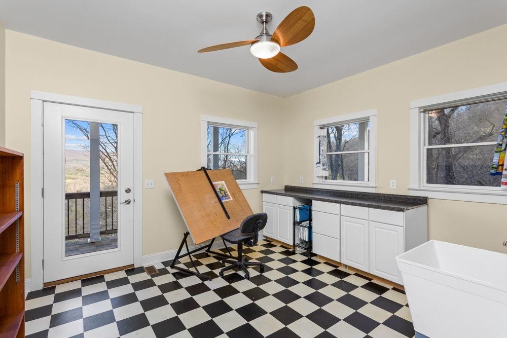 9586 Brunk Spring Lane Broadway, VA 22815 - Photo 16 of 58 a living room with a black white checkered floor with a dining table and chairs