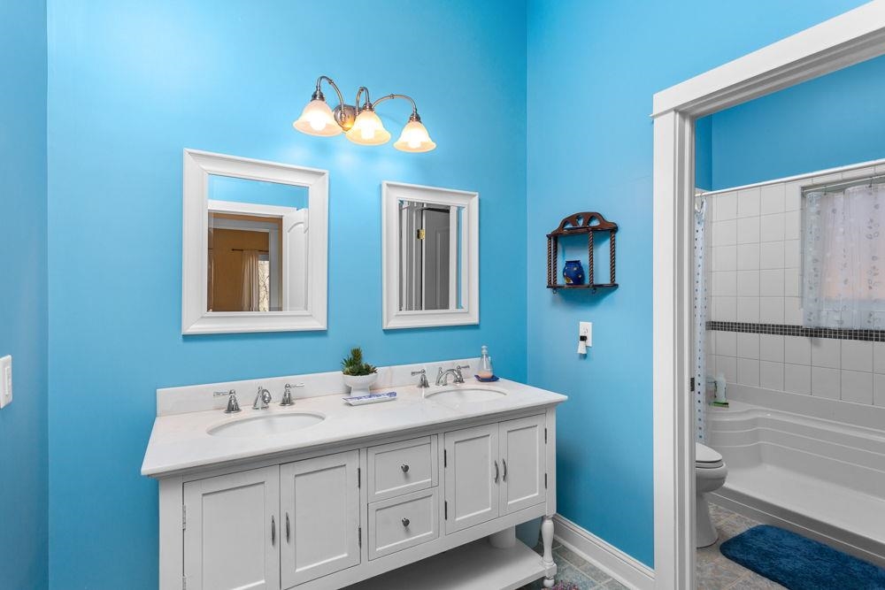 9586 Brunk Spring Lane Broadway, VA 22815 - Photo 41 of 58 a bathroom with a double vanity sink and a mirror