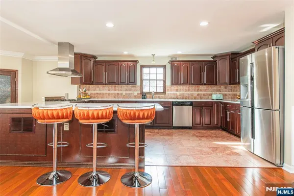 a kitchen with stainless steel appliances granite countertop a refrigerator and a stove top oven