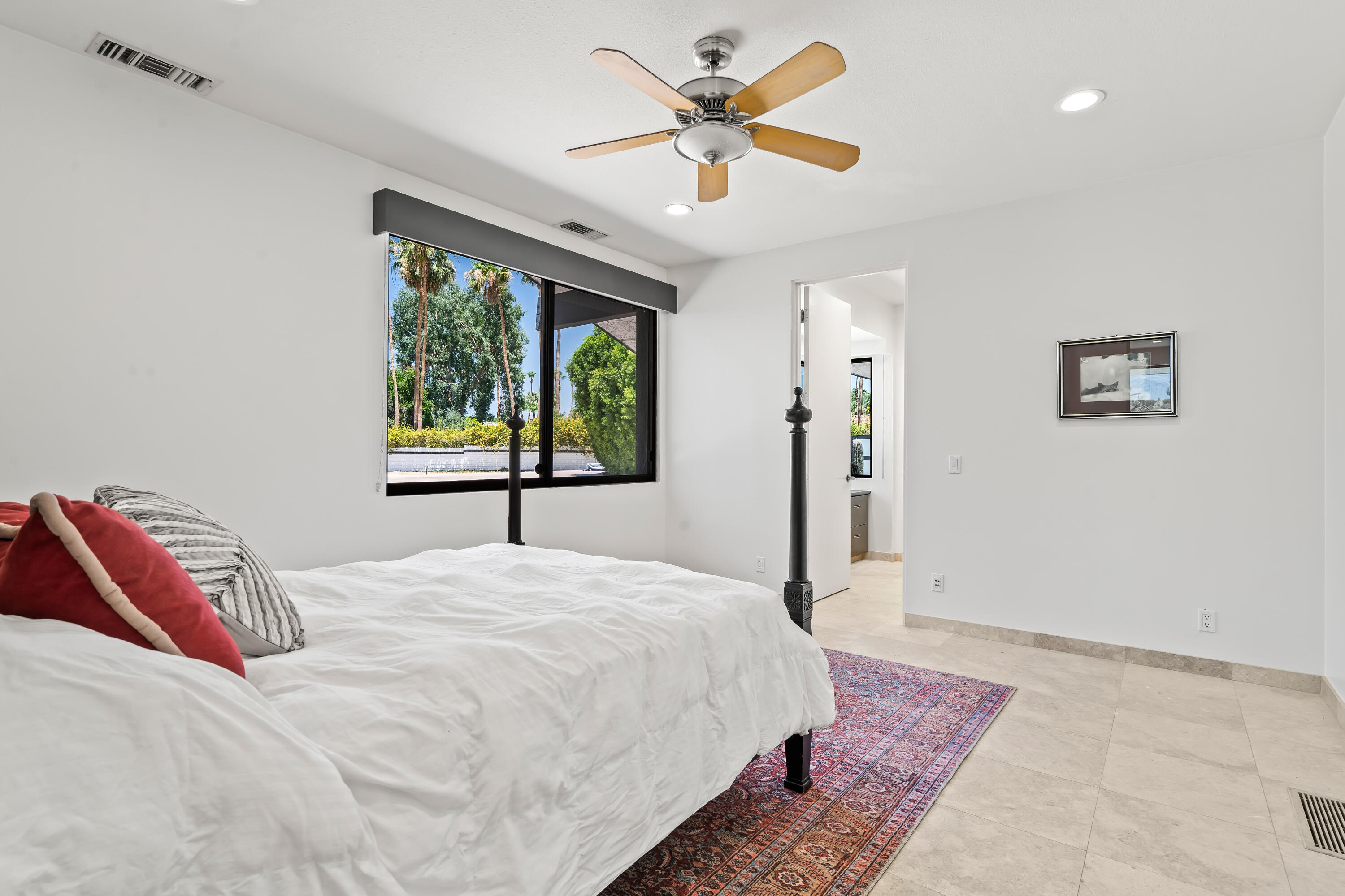 401 Iris Lane Rancho Mirage, CA 92270 - Photo 44 of 87 a bedroom with a large bed and a chandelier