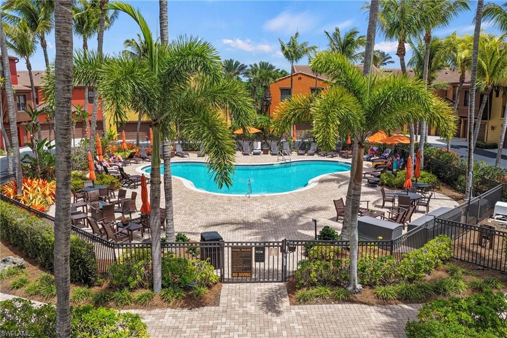 9098 Capistrano Street South, Unit 7103 Naples, FL 34113 - Photo 2 of 36 Community pool featuring a gate and a patio
