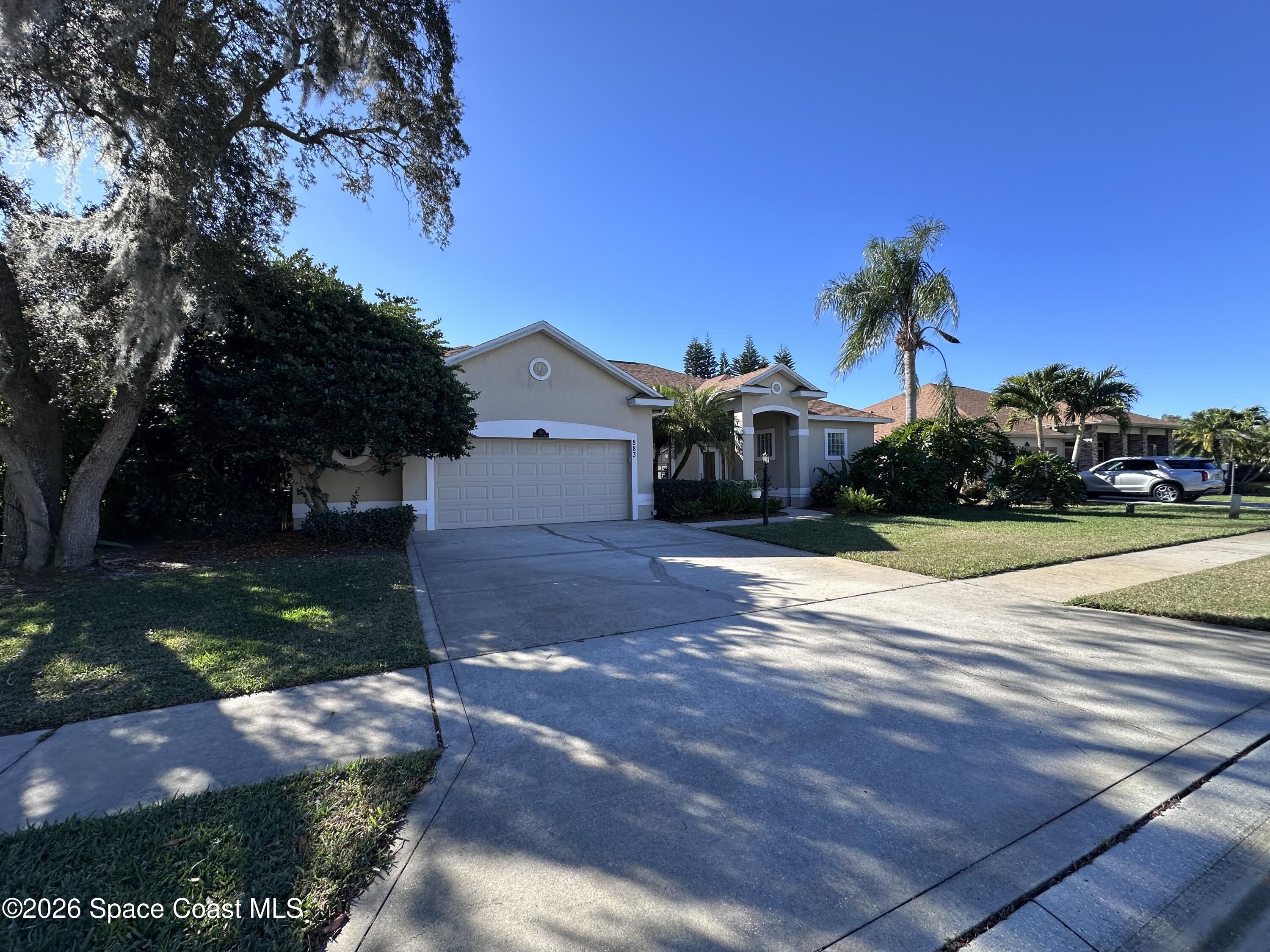 883 Spring Oak Drive Melbourne, FL 32901 - Photo 2 of 45 a view of a street with a yard