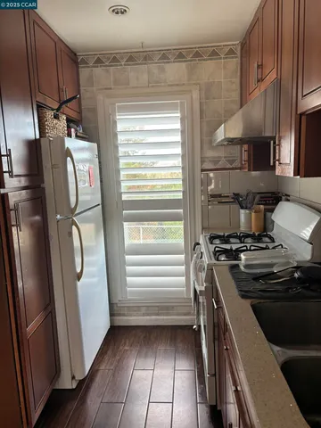 a kitchen with stainless steel appliances granite countertop a refrigerator and a stove