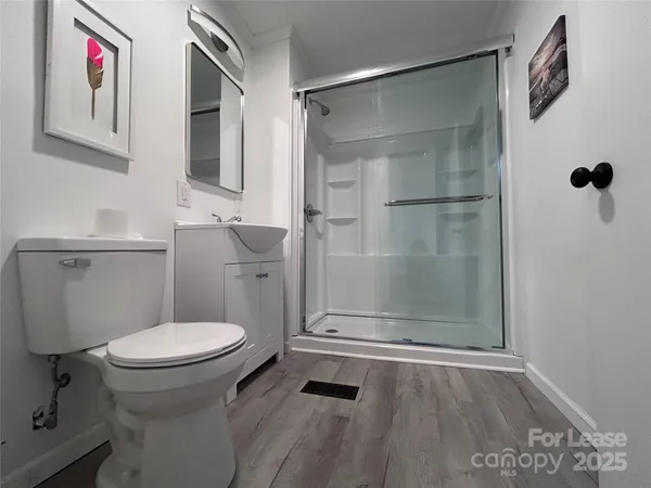 a bathroom with a granite countertop toilet and a shower