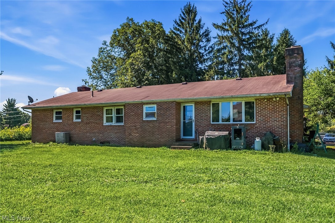 6890 Refugee Road Pickerington, OH 43147 - Photo 33 of 49 Brick exterior featuring a brown shingle roof and a rear entry door