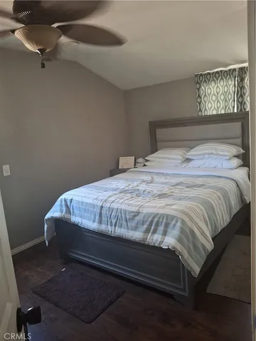 a bedroom with a bed rug and wooden floor