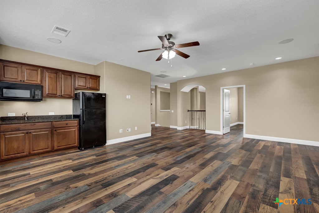 2194 Ranch Loop Drive New Braunfels, TX 78132 - Photo 25 of 48 a view of a kitchen with wooden floor and a ceiling fan