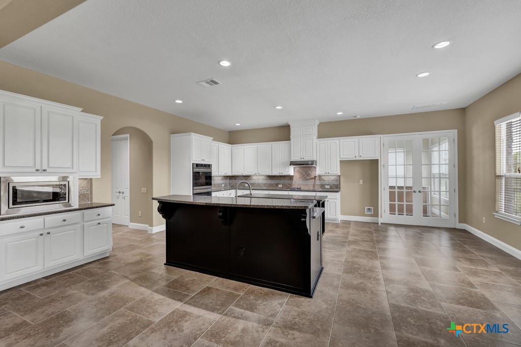 2194 Ranch Loop Drive New Braunfels, TX 78132 - Photo 9 of 48 a large kitchen with stainless steel appliances granite countertop a large counter top and a stove top oven