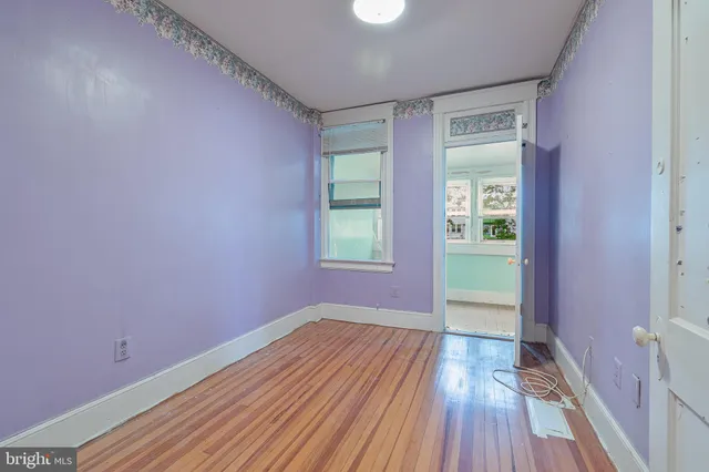 a view of a room with wooden floor and a window